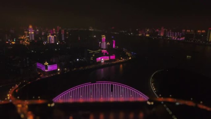 夜间照明武汉市滨江酒店和桥梁空中全景4k倾斜移位中国