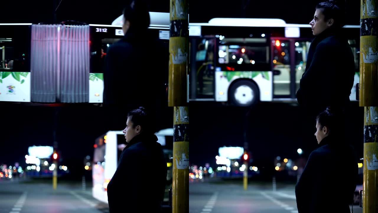 担心孤独的女人晚上在公共汽车站等着某人