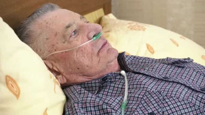 老人躺在家里的床上，鼻子里有医用氧气导管