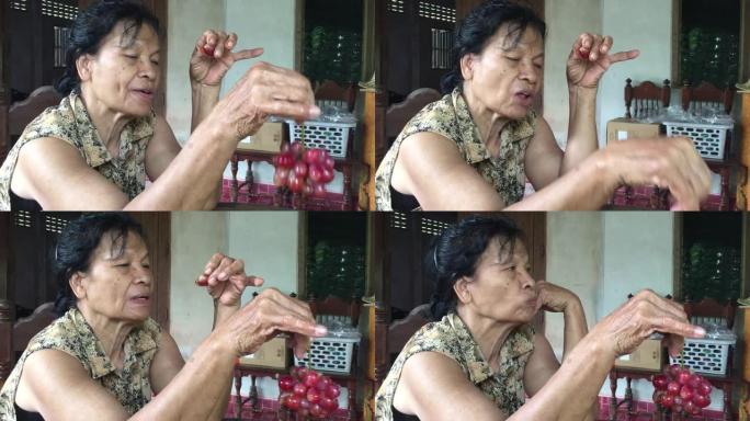 亚洲老年妇女吃红葡萄