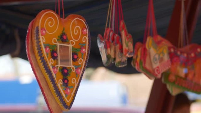 悬挂在节日帐篷下面的马形状的Licitars心和姜饼。街头拍卖会上袋装糖果。
