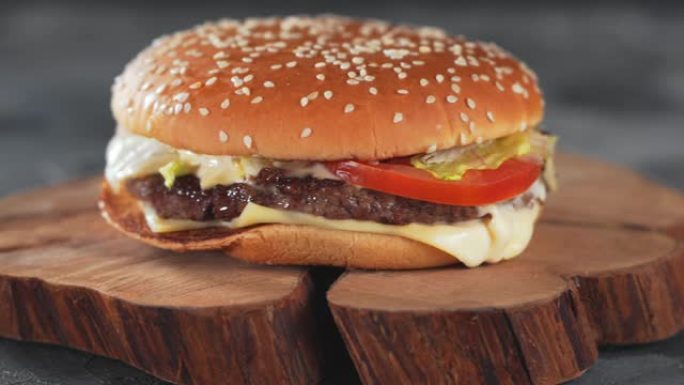 新鲜美味的自制牛肉汉堡放在桌子上的木盘上，全景幻灯片拍摄