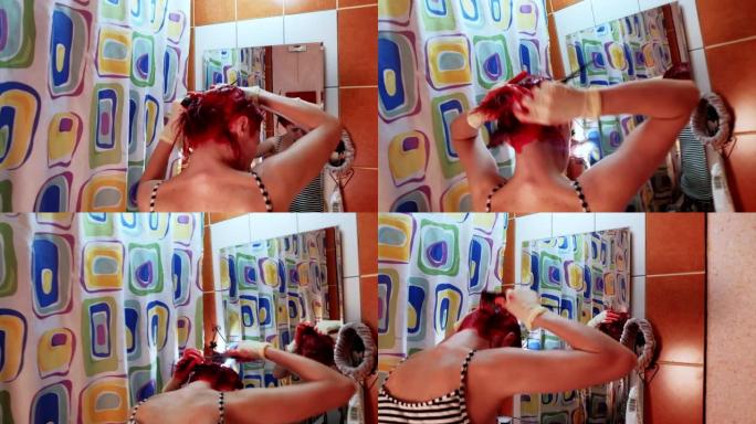 一个在家的女人把头发染成红色。镜子里的反射