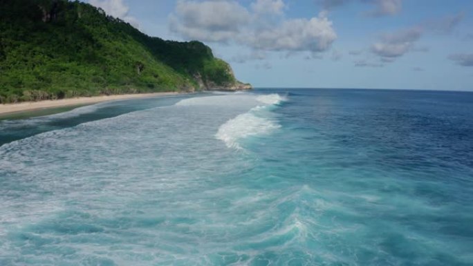 鸟瞰海洋，美丽的泡沫滚滚波浪，背景上的山