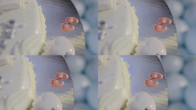 美味的生日、洗礼或婴儿淋浴蛋糕，顶部装饰有新生儿睡眠，底部有小脚。小男孩派对用蓝色和白色蛋糕。