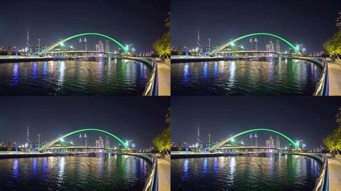 公差桥。湖泊或河流的建筑结构，迪拜市中心的天际线，阿拉伯联合酋长国或阿联酋。夜间城市的金融区和商业区