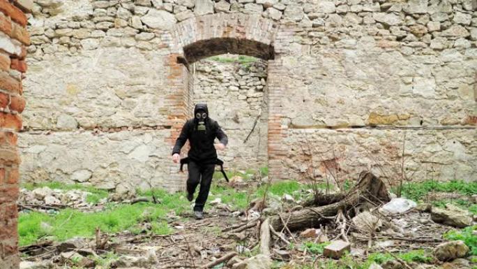 一个穿着黑色衣服和防毒面具的流浪男子穿过一栋废弃的建筑物。后世界末日世界。跟踪者概念，核或化学战争后