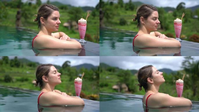 年轻女子在游泳池里放松，周围是美丽的大自然。在印度尼西亚拍摄。4k慢动作