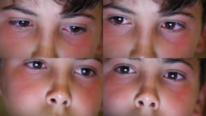 儿童脸特写眼睛在晚上看着设备屏幕