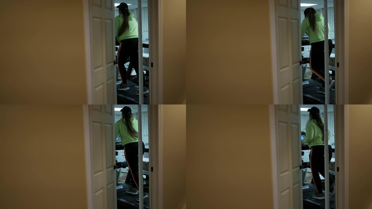 高加索年轻女子正在住宅地下室的跑步机上跑步-角度2