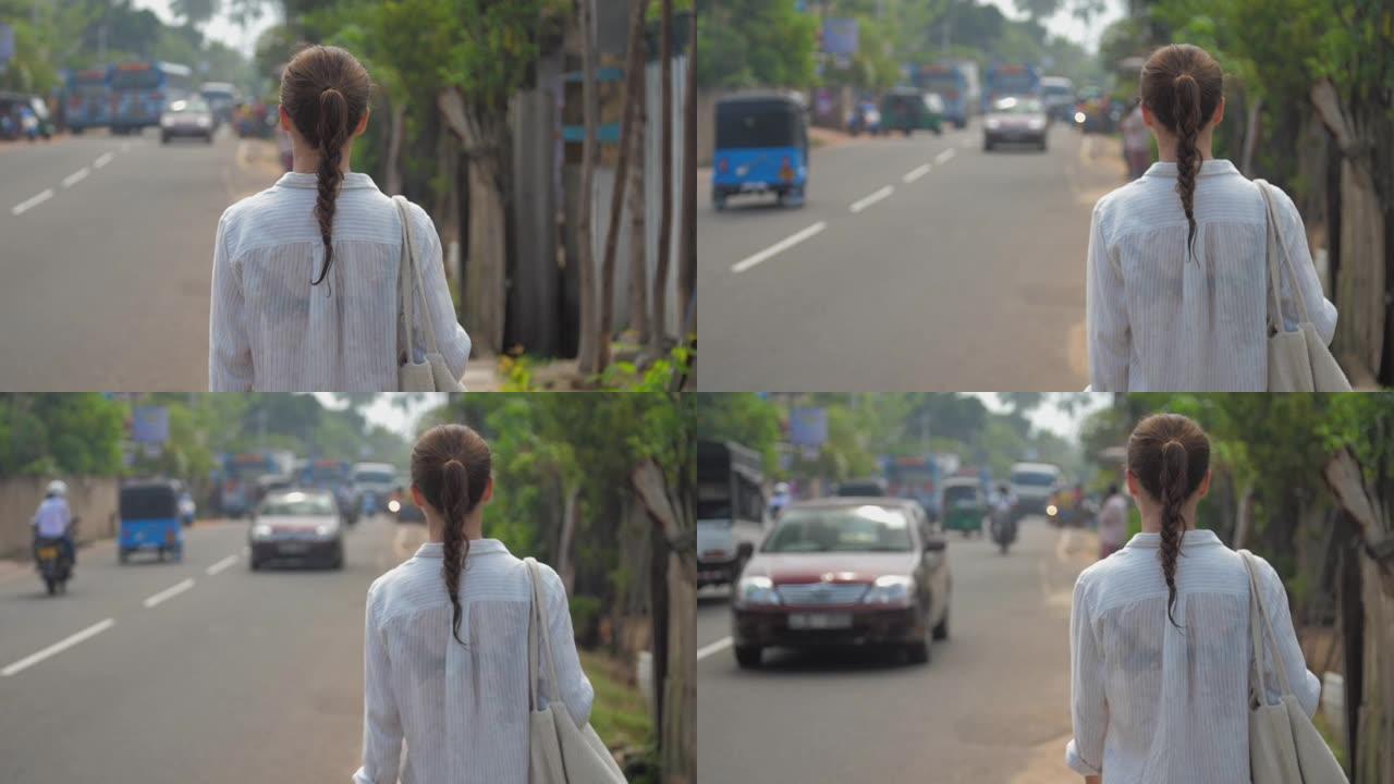 女孩沿着道路走过热带城市的车辆