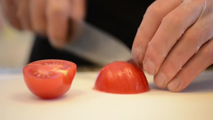 一位厨师正在专业切菜板上切番茄