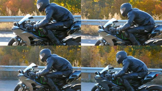 戴着头盔的男子在高速公路上骑着摩托车，背景是太阳耀斑。摩托车手在秋天的乡村路上驾驶摩托车。慢动作侧视