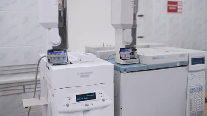 研究科学家分析试管的自动化实验室机器。食品工业实验室测量烧瓶和试管中的酒精饮料生产参数。