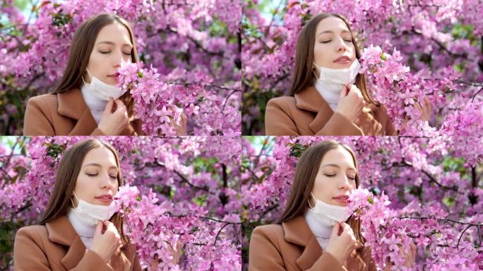 一个戴着医用口罩的女孩站在一棵开花的树附近。冠状病毒流行病。新型冠状病毒肺炎