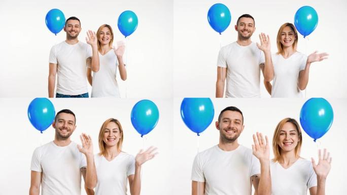 微笑的男人和女人举起双手问候并拿着气球