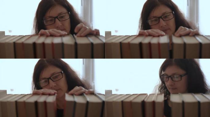 年轻女子选择书架上的书。戴眼镜的年轻迷人女学生从书架上拿书，翻阅图书馆的书页。读书爱好。