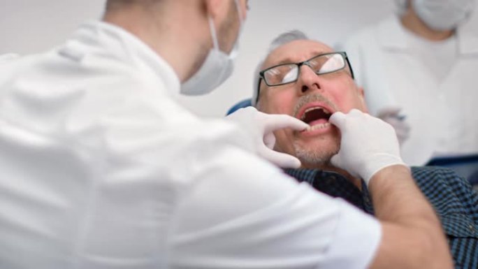 近男牙医尝试假颌样本在高级男子牙科。4k Dragon RED摄像机