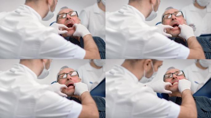 近男牙医尝试假颌样本在高级男子牙科。4k Dragon RED摄像机