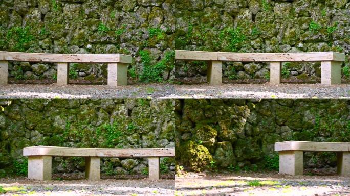 用石头制成的圆形长凳位于公园内，由单个大石头制成的石墙前