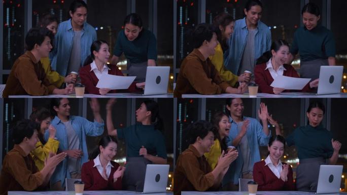 亚洲女性领导者和ux/ui设计师为平板电脑的移动应用界面线框设计在晚上的现代办公室鼓掌。在创意数字开