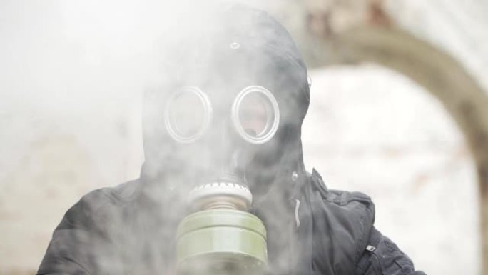肖像。特写。烟雾中戴着防毒面具的人。环境污染的概念。生态灾难慢动作。