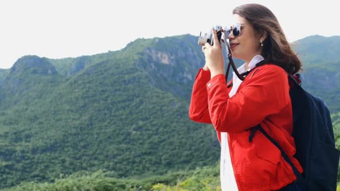 快乐亚洲女人复古相机与自然背景，露营概念。