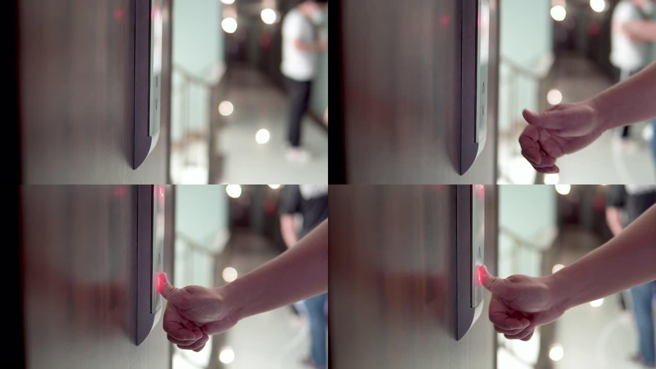 手指按下电梯的向下按钮。