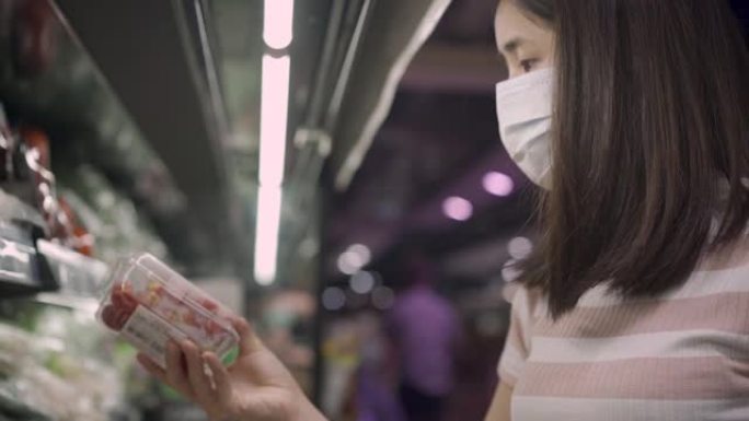 戴着面具的年轻亚洲女性去杂货店购物，新型冠状病毒肺炎日冕病毒大流行期间的生活方式，家庭烹饪准备，储备