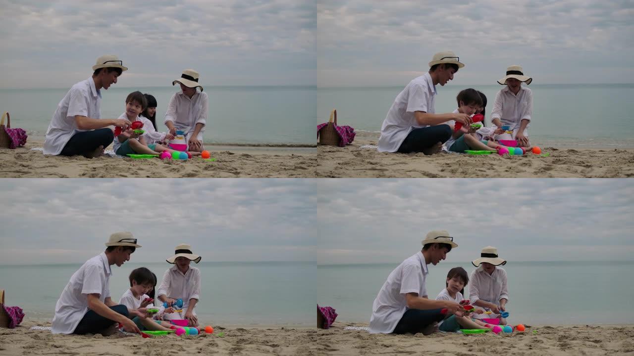 亚洲家庭度假在沙滩上玩耍，一起堆沙子。