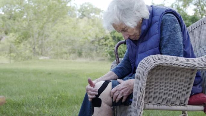 夏季户外中午，一名老年高加索妇女的膝关节关节炎疼痛的个人资料