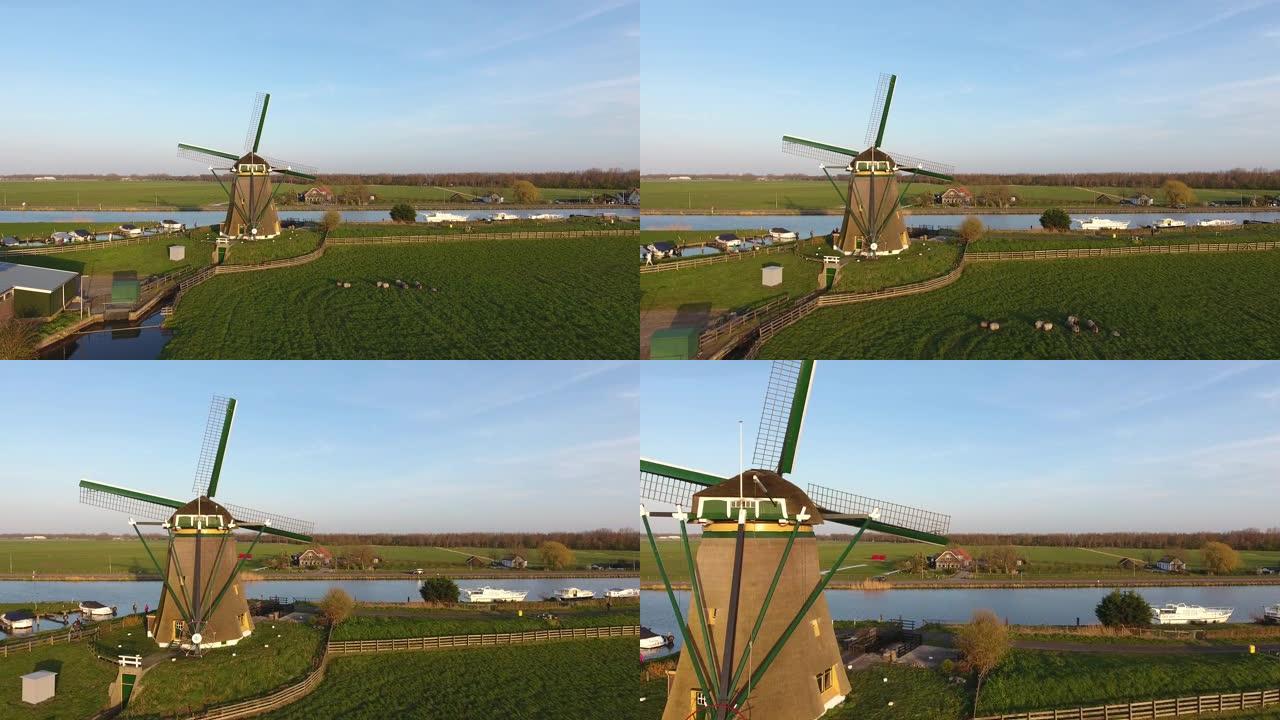 日落时分，古老的荷兰风车，前面有草，绵羊随船和蓝天走来走去，人们骑着自行车