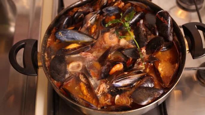 在炉子上烹饪传统的意大利地中海鱼汤，杂烩，虾，贻贝番茄，鱿鱼，蛤。海鲜。顶视图