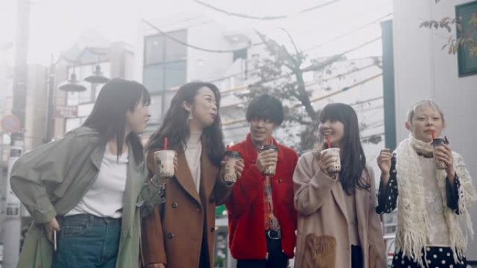 一群时髦的日本年轻人带着珍珠奶茶在原宿散步