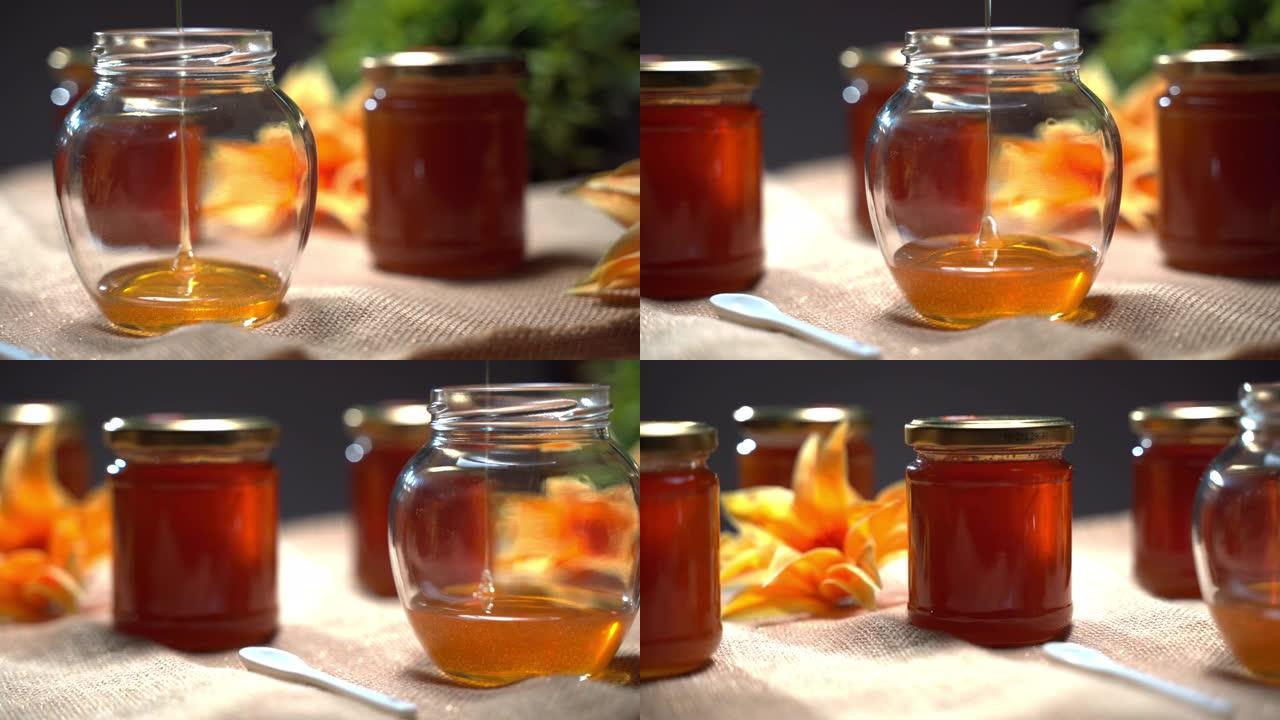 土气生产的蜜罐，浓稠的金色蜂蜜滴在玻璃碗中。甜蜜蜜健康饮食，罐装蜂蜜，药物治疗