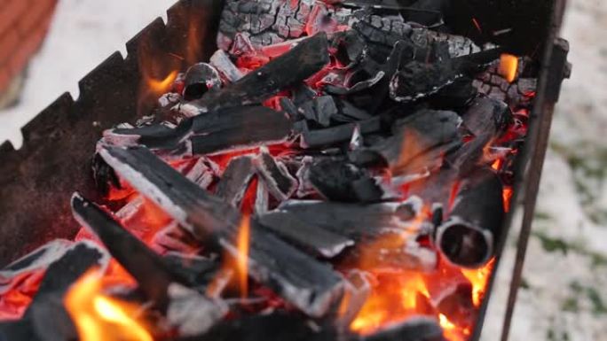 烧烤架上烧煤。热煤和烟焰。近距离烧烤。火焰和红色余烬。餐厅烧烤的火和烧烤准备