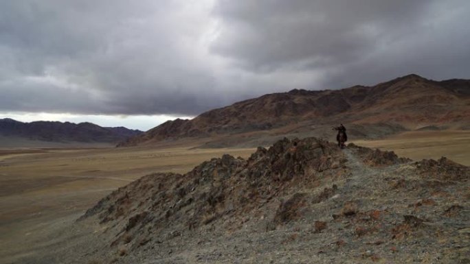 蒙古沙漠中骑着马的猎鹰者