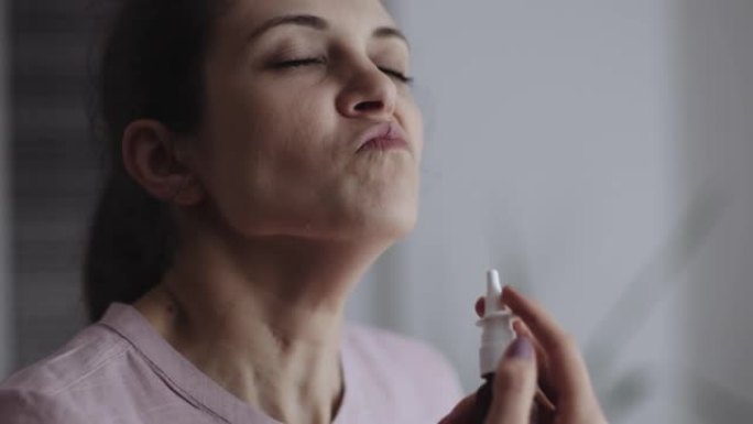 用鼻腔喷雾剂来解决鼻子充血的女人。股票视频
