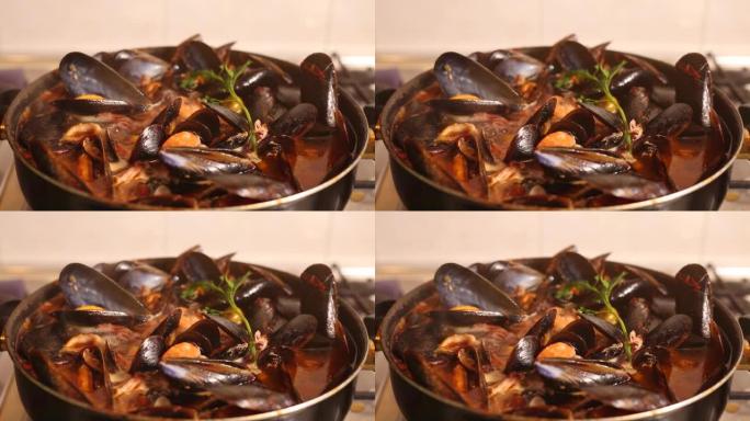 在炉子上煮传统的意大利地中海鱼汤，杂烩，虾，贻贝番茄，鱿鱼，蛤。海鲜