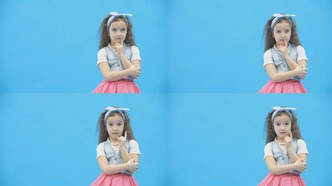 小女孩在4k慢动作视频中决定蓝色背景。