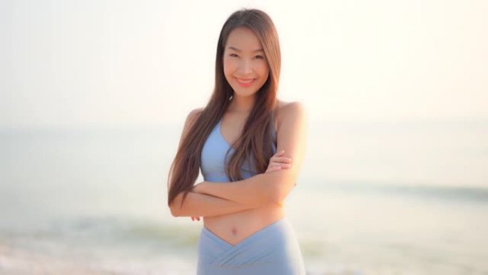 年轻的亚洲女人快乐的微笑放松环顾海滩海洋