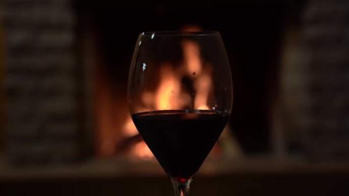 在乡间别墅舒适的壁炉前喝一杯红酒。