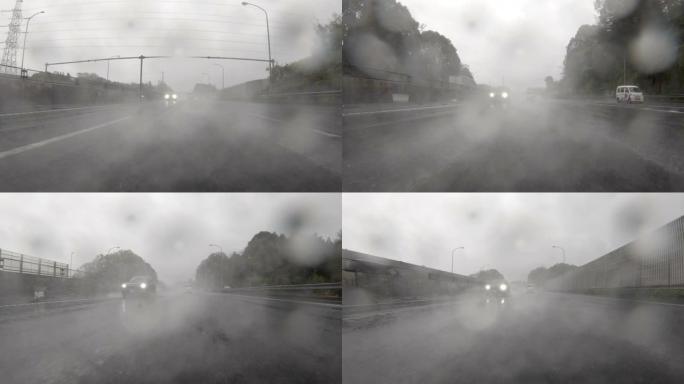 驾驶通过多雨的高速公路/后视图
