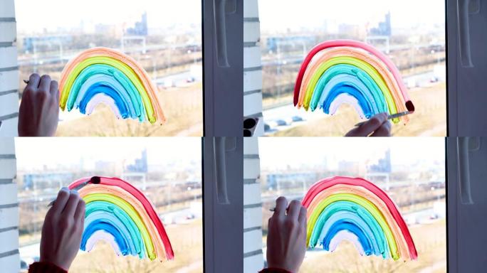 4k。女孩在家里新型冠状病毒肺炎检疫时在窗户上画彩虹。呆在家里社交媒体预防冠状病毒的运动，让我们一切