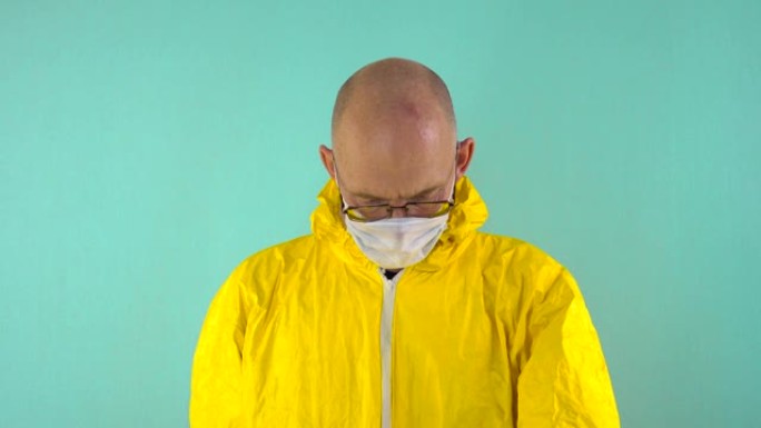 一位穿着黄色防护服，口罩和眼镜的化学科学家在蓝色背景上拿着一个带有蓝色液体的烧瓶，研究其中的内容，然