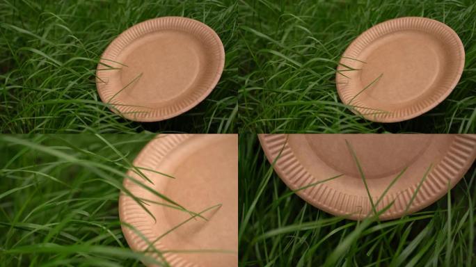 绿色草地背景上的一套一次性生态器皿的4k生态自然板。地球的可持续性。不要使用塑料。甘蔗渣和竹纤维制成