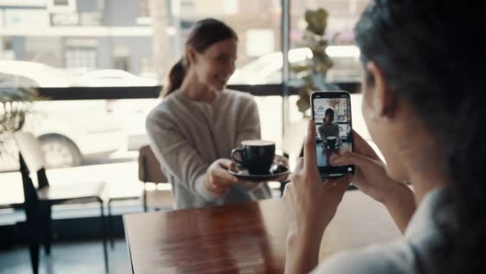 女人在咖啡馆里拍她的朋友拿着咖啡