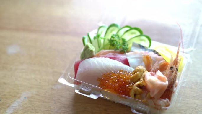 木制桌子上的塑料容器中的日本食物