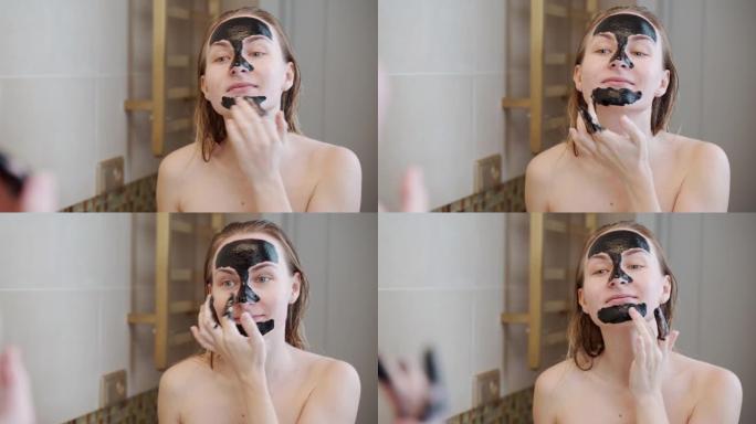 女人在脸上戴了一个黑色面具。照顾油性皮肤的女人。美容治疗。护肤品