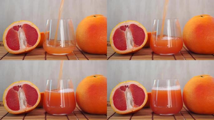将果汁柑橘维生素汁倒入带有水果的透明玻璃杯中。